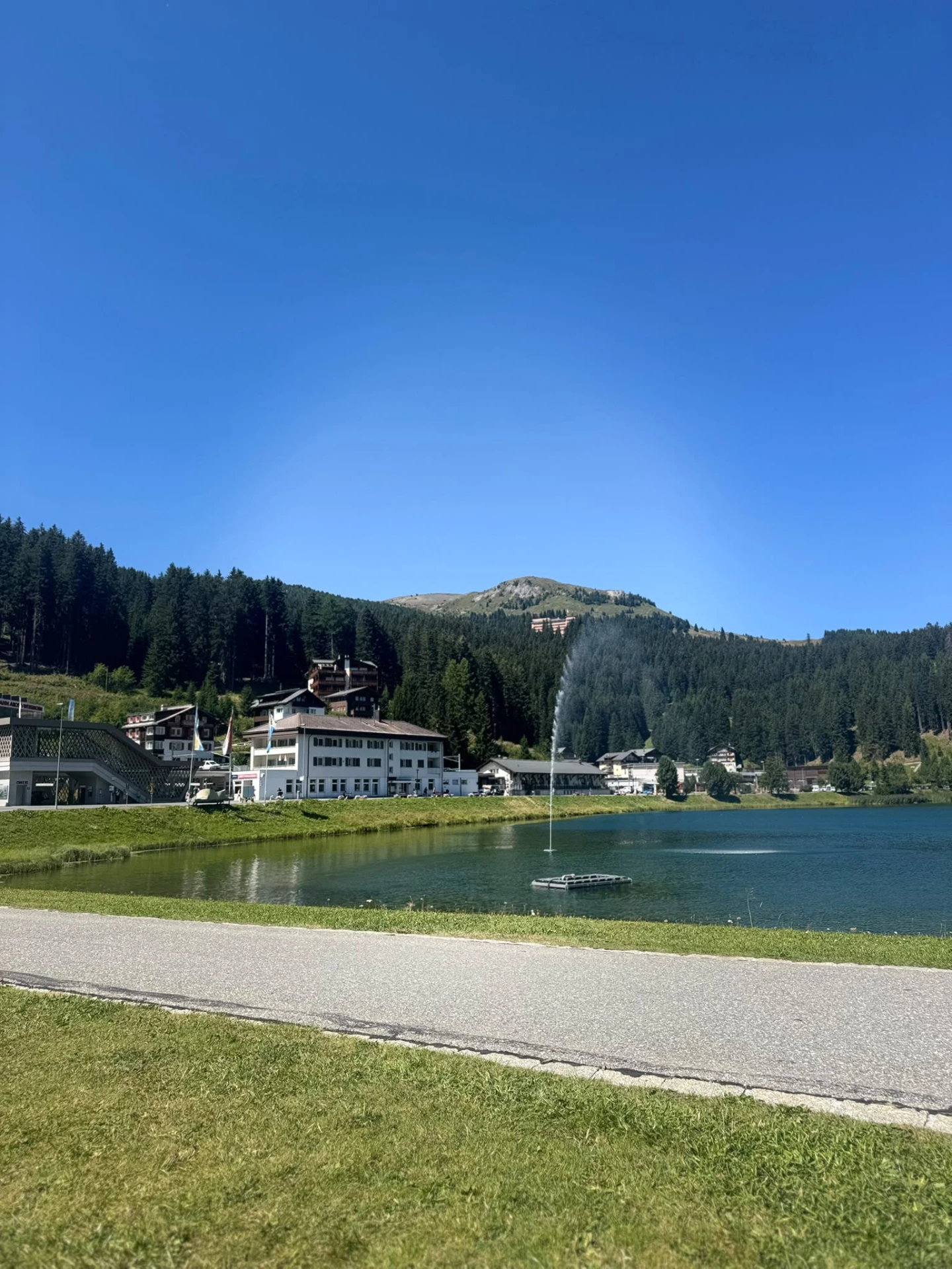 Alpine lake with fountain and chalets in Arosa, Switzerland